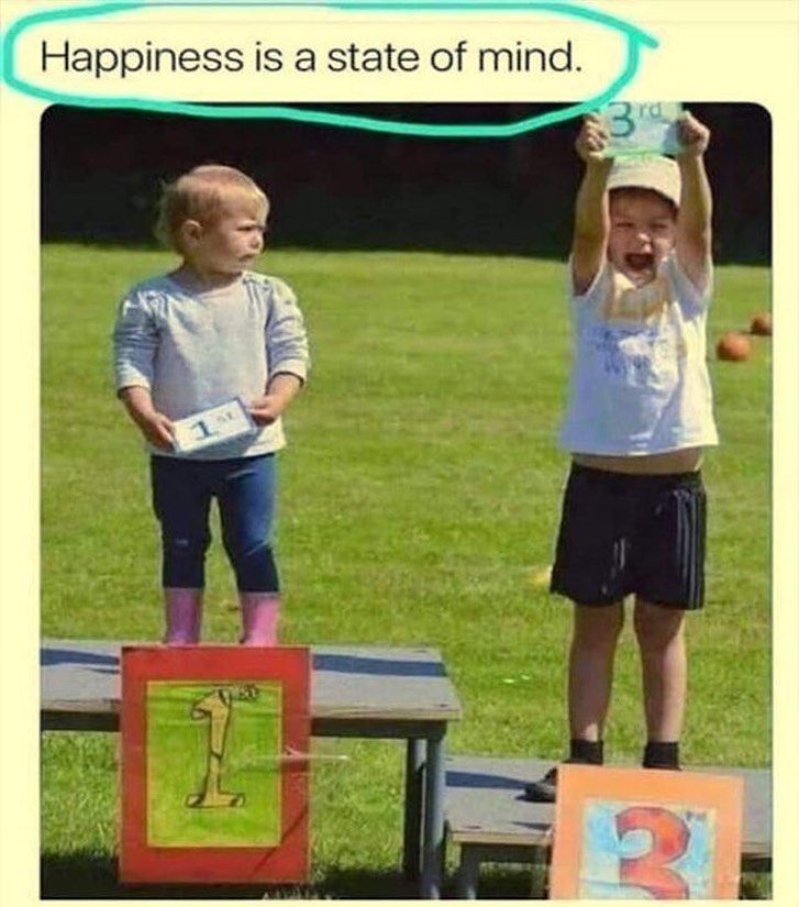 a child holding a 3rd place sign is visibly happier than the child holding the 1st place sign.